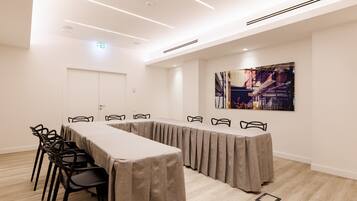 A conference room with a long table, chairs, and a modern ceiling design.