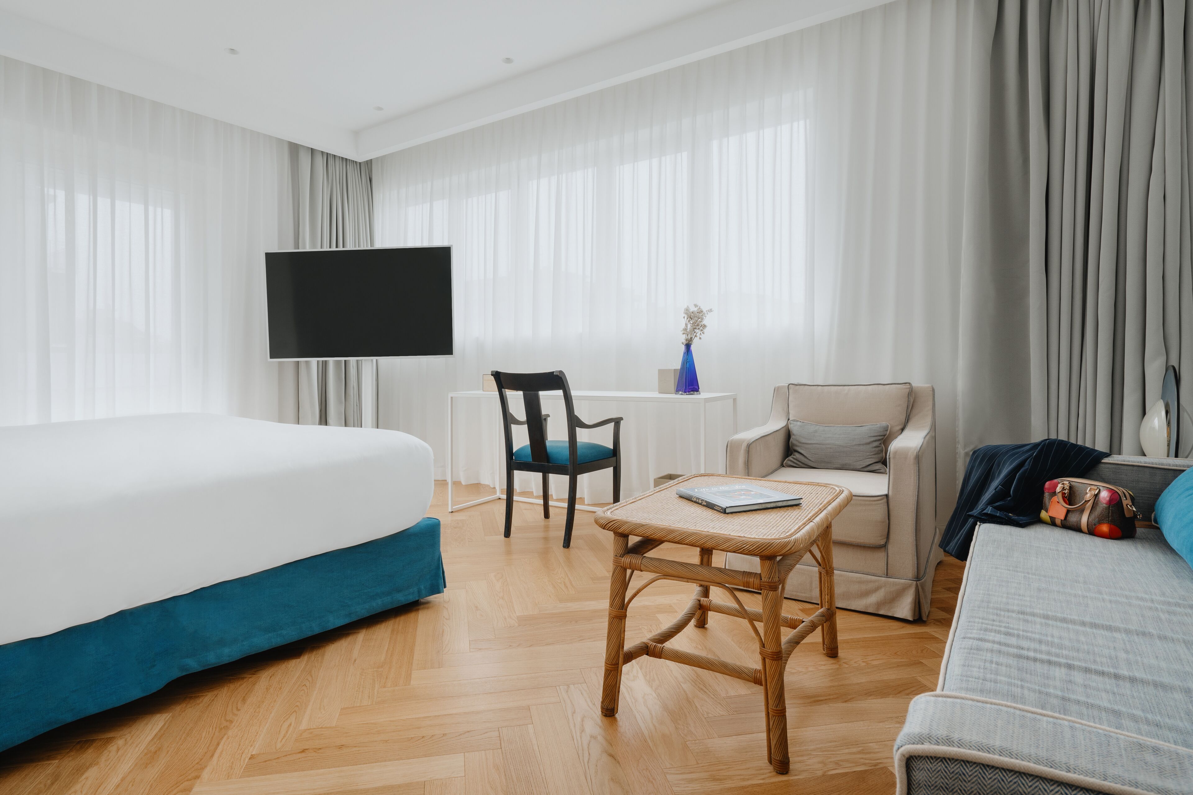 Une chambre d’hôtel équipée d’un lit, d’un bureau, d’une chaise, d’un canapé et d’une télévision.