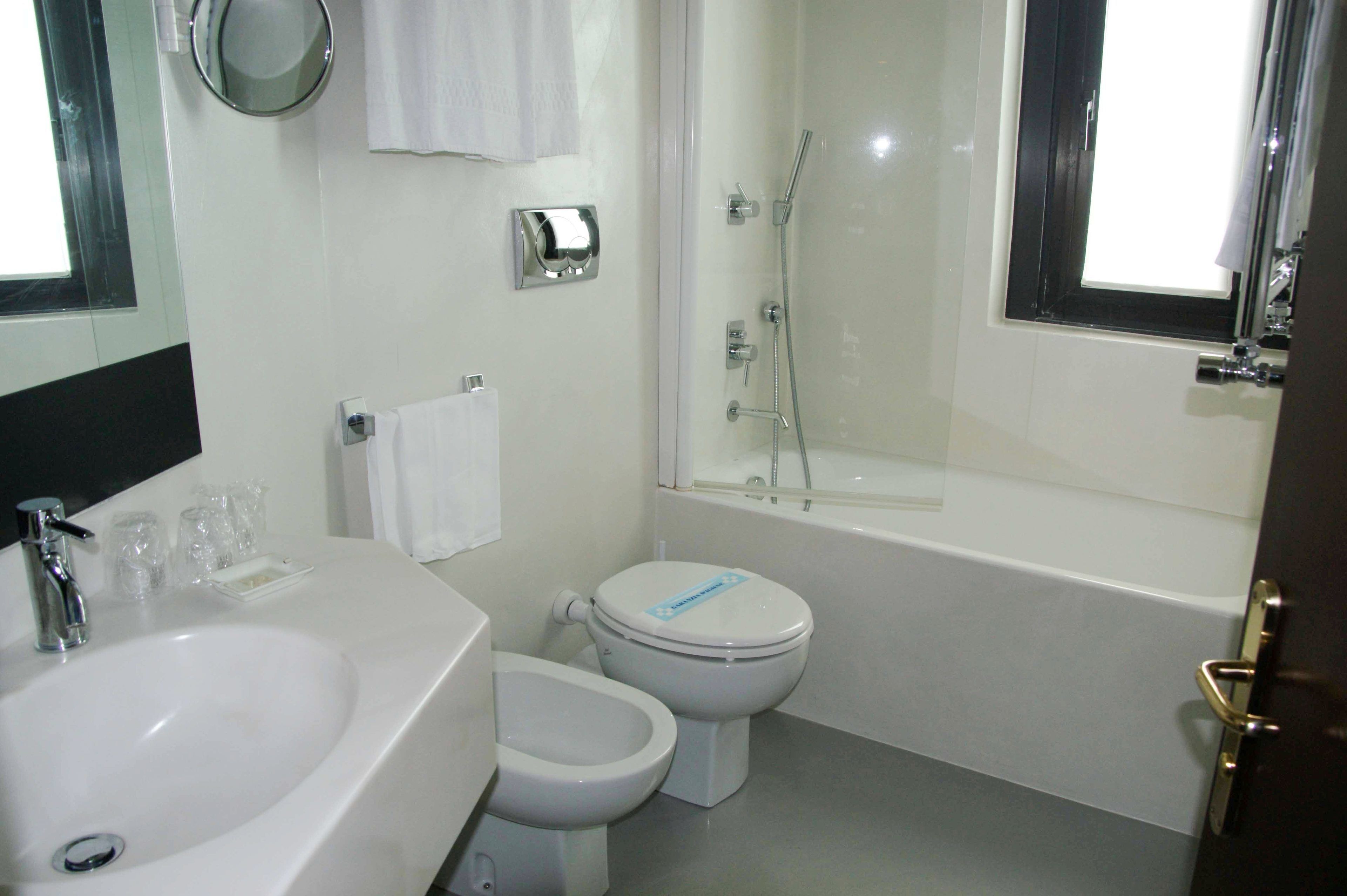 Un baño con lavamanos, inodoro y bañera.
