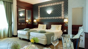 A hotel room with two beds, a dining table set with silverware, glasses, and a flower arrangement. - c-hotels Concorde (Milan)