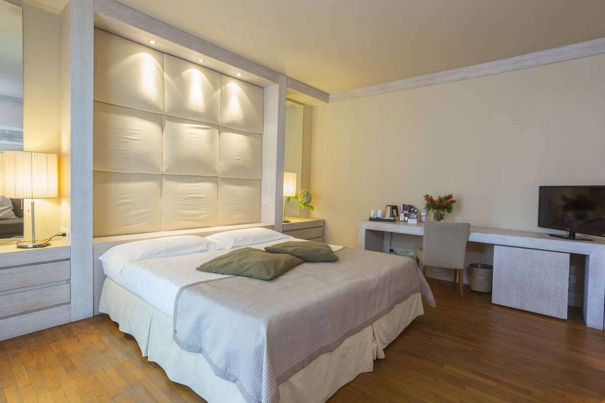 Une chambre d’hôtel moderne, dotée d’un grand lit, d’un bureau et d’une télévision.