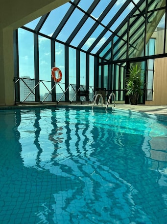 Una piscina techada, sillones reclinables de piscina