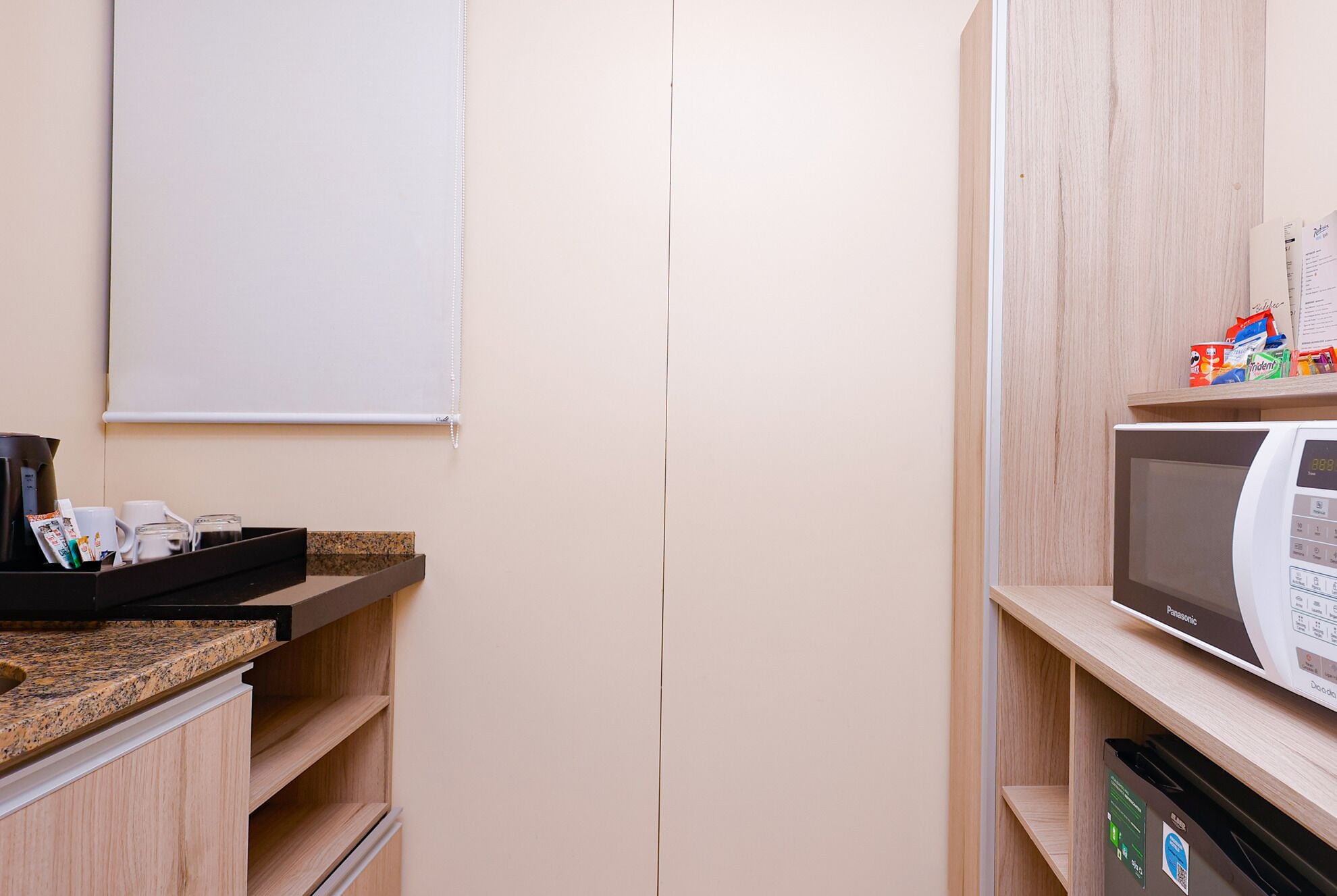 A kitchenette with a microwave, coffee maker, and a small refrigerator.