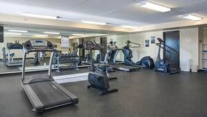 Un gimnasio con cintas de correr, elípticas y pesas sueltas.