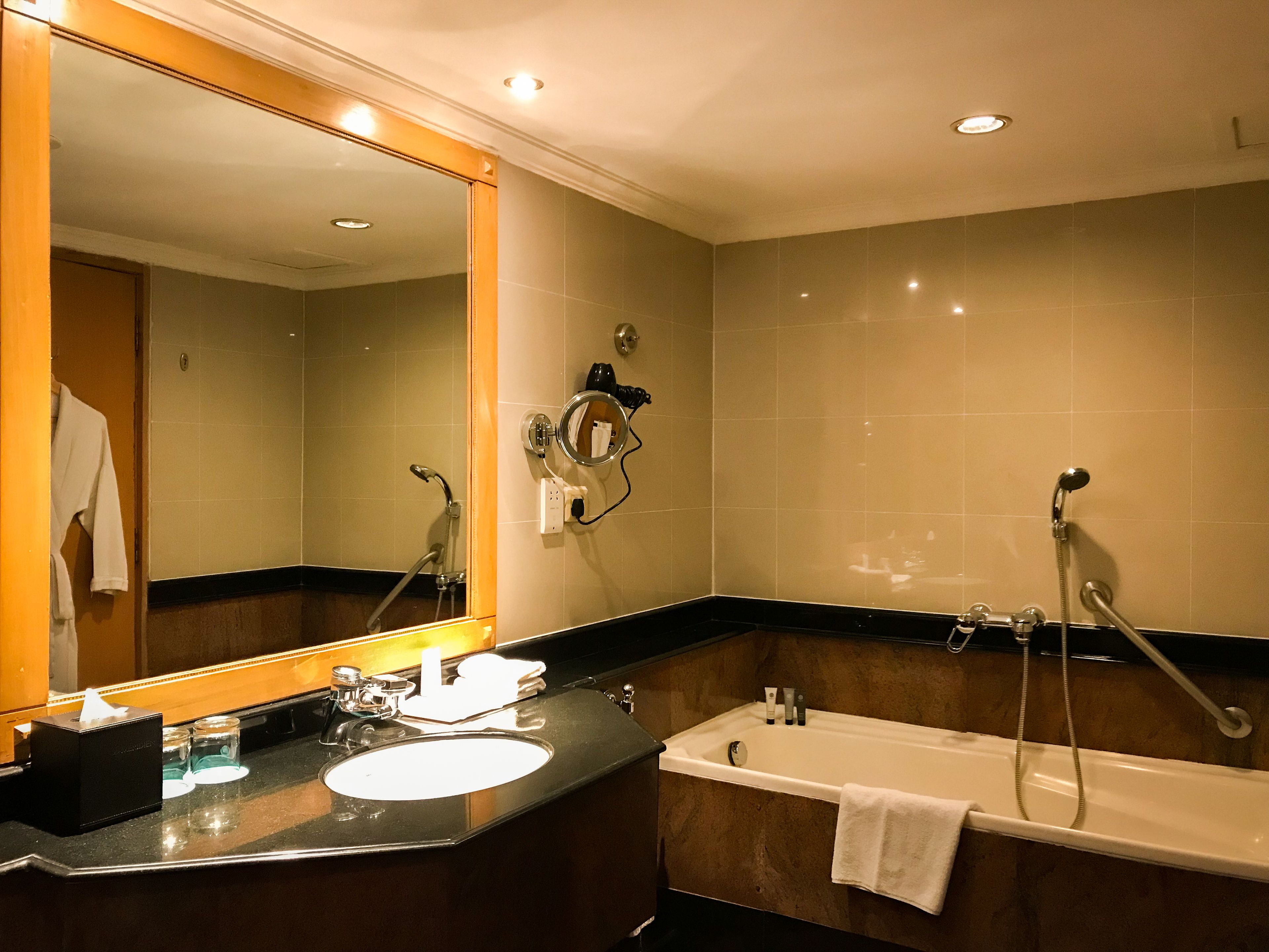 A bathroom with a sink, mirror, and bathtub.