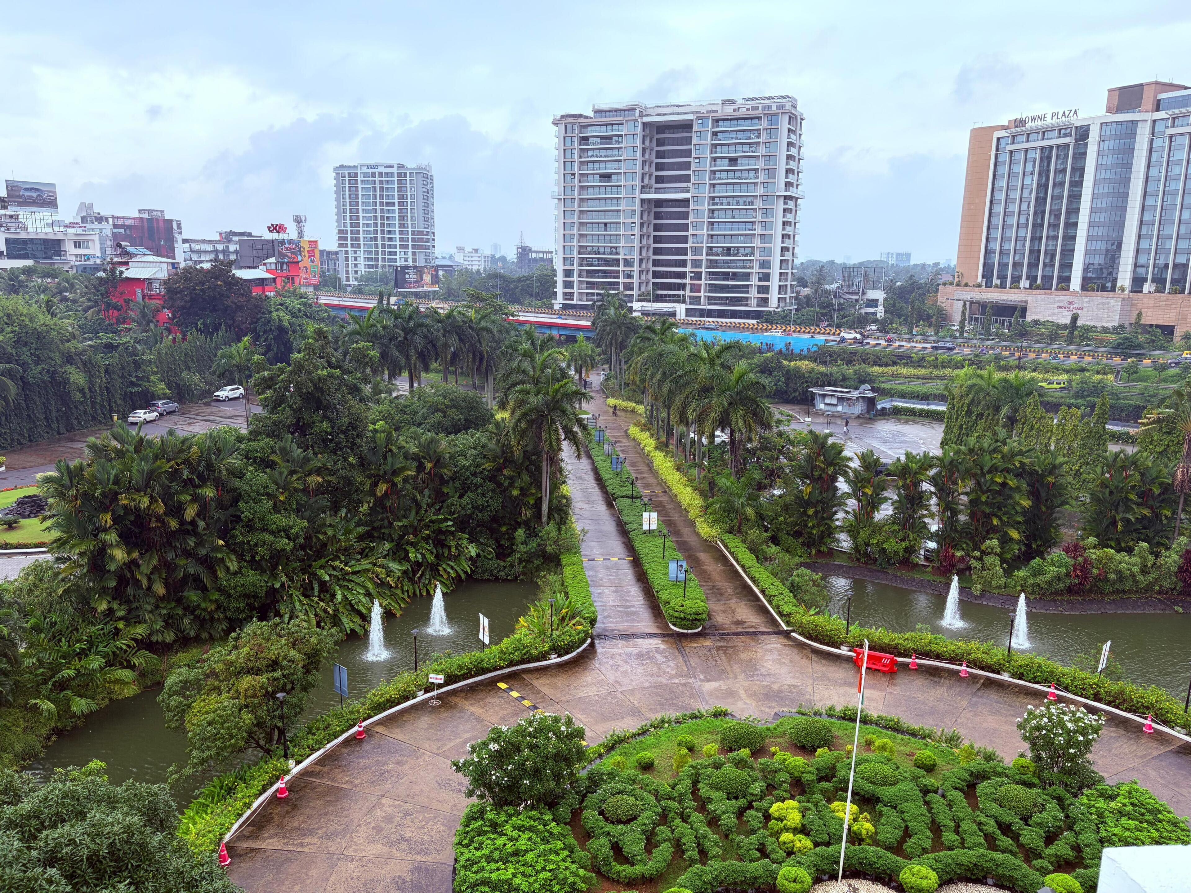 A landscaped area with a water feature, palm trees, and a pathway.