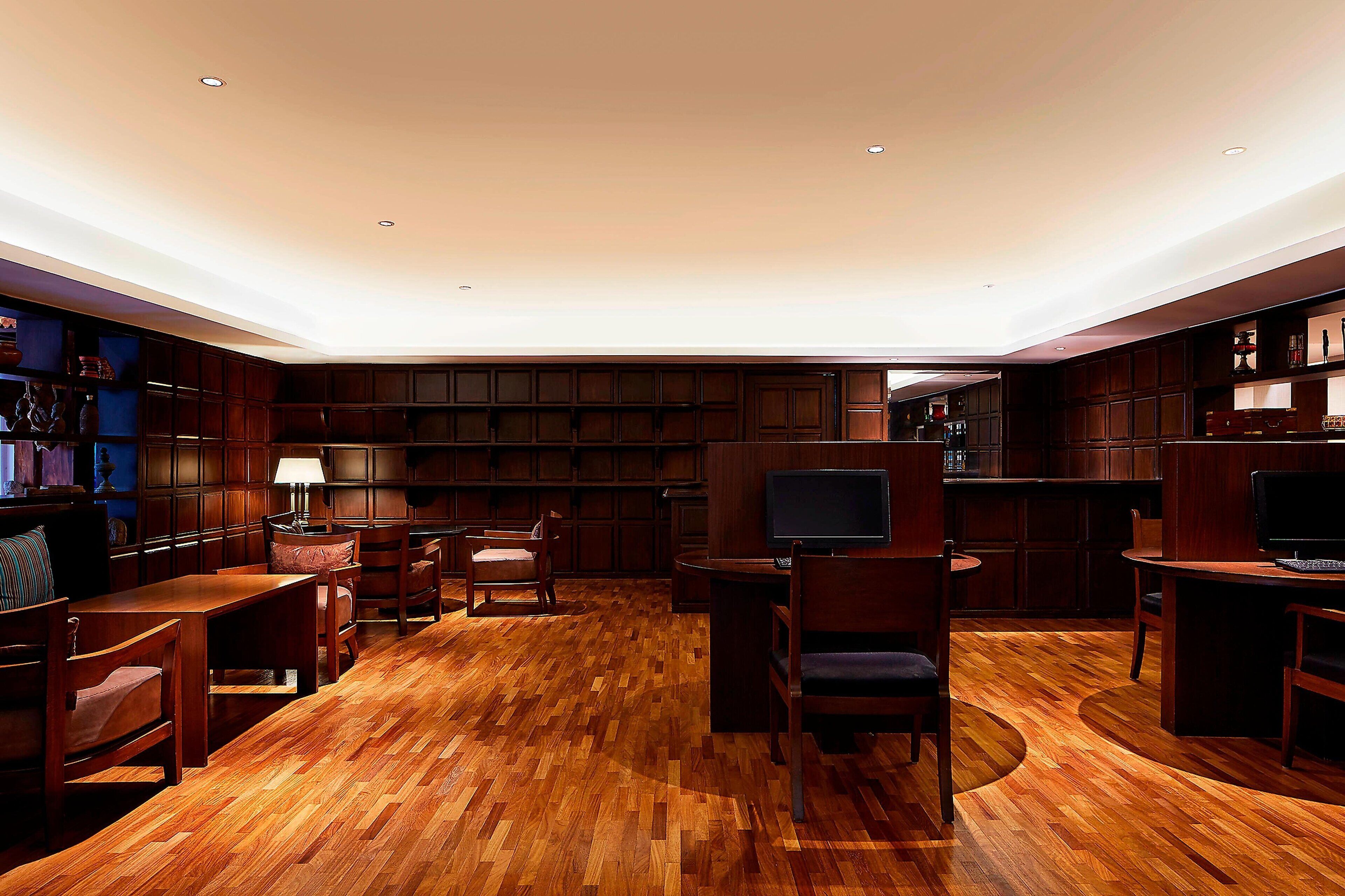 Un'ampia stanza con pavimento in legno, librerie integrate e televisore.