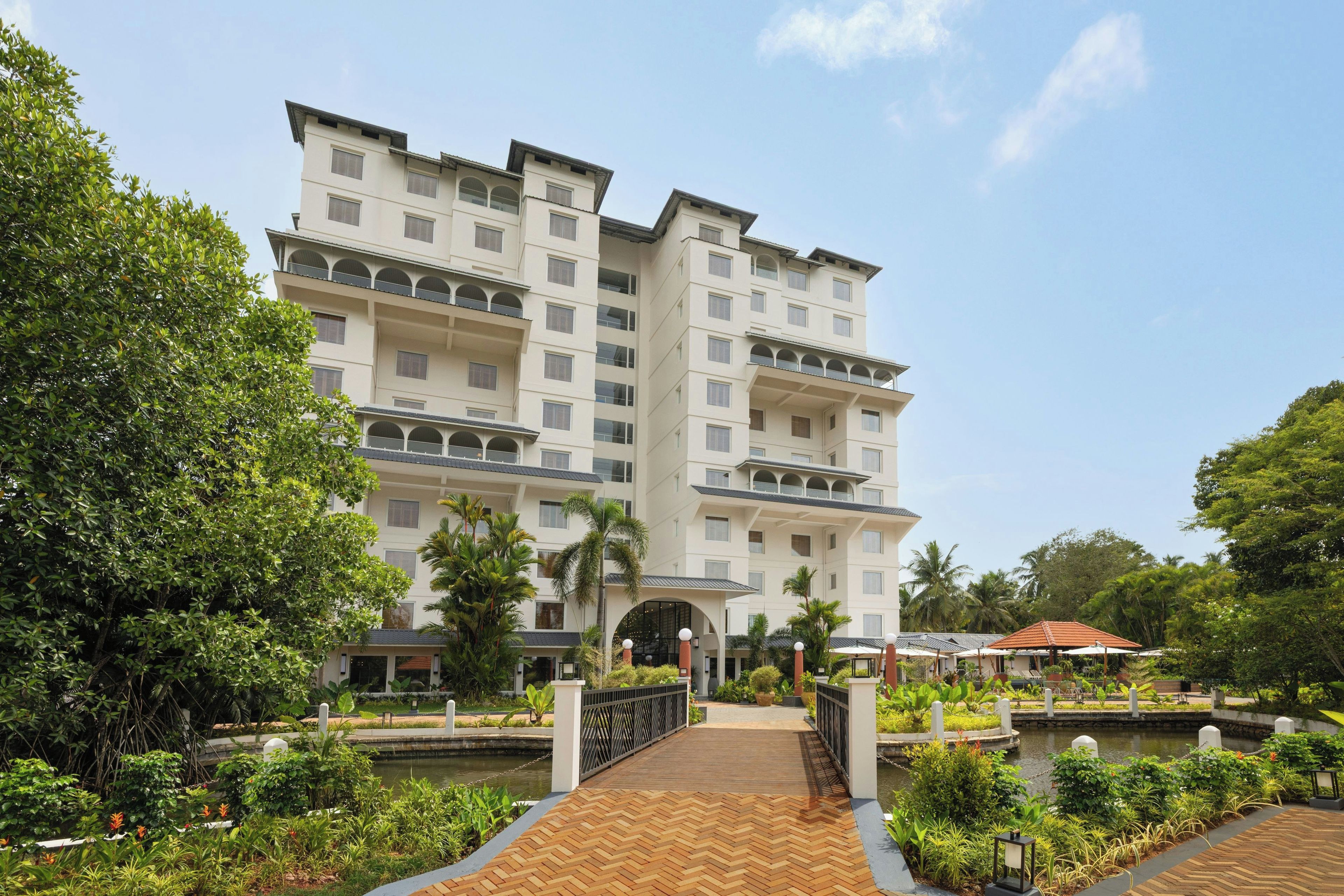 A multi-story hotel with a central courtyard, a bridge, and a pool.