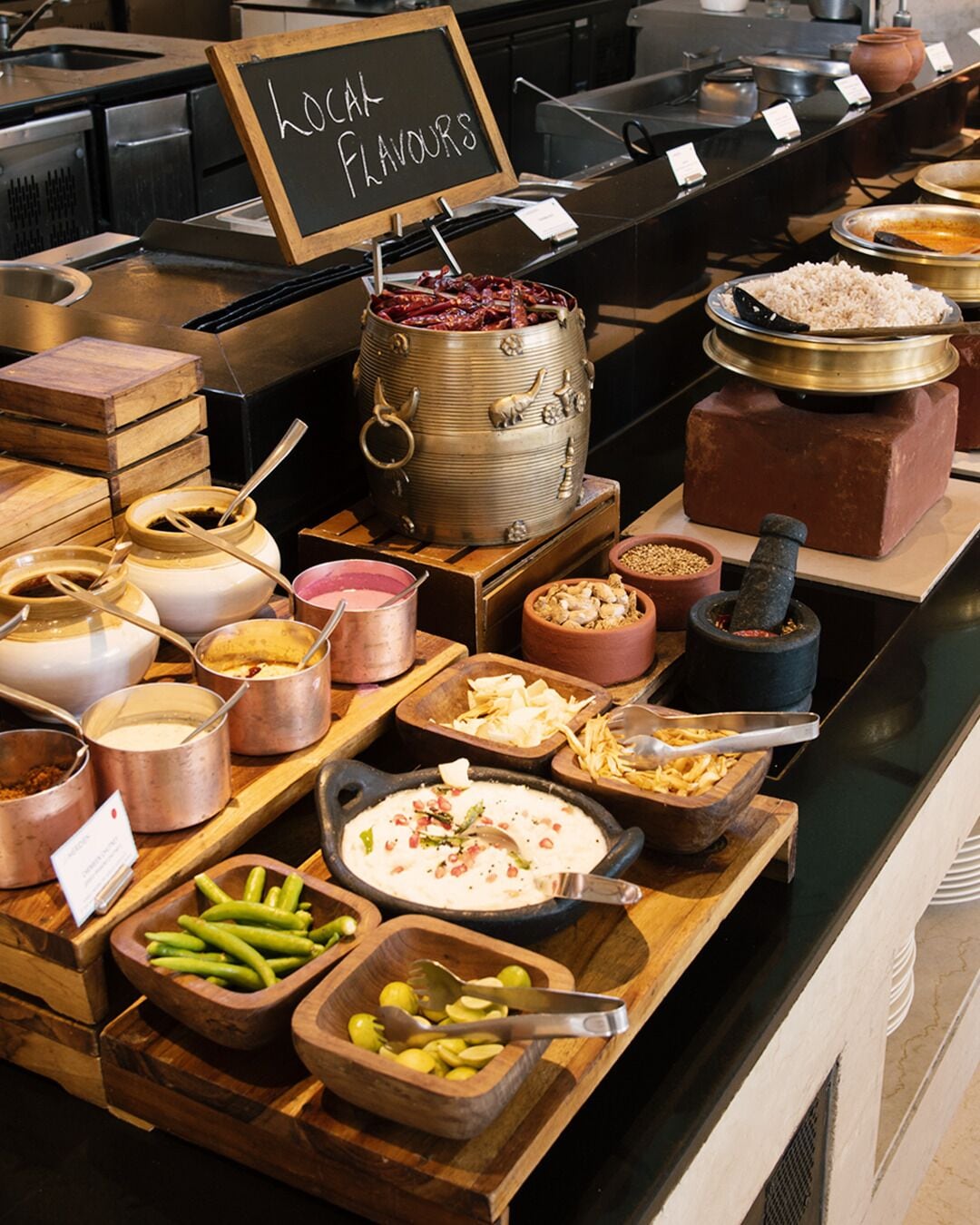 A buffet with various food items and a sign indicating 'local flavours'.