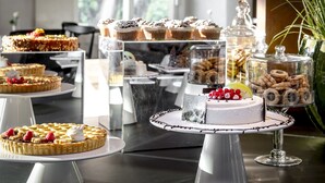 A variety of desserts on display, including cakes and pastries, arranged on multiple serving stands.