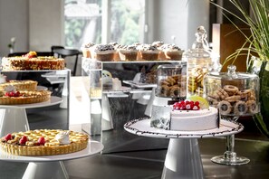 A variety of desserts on display, including cakes and pastries, arranged on multiple serving stands.
