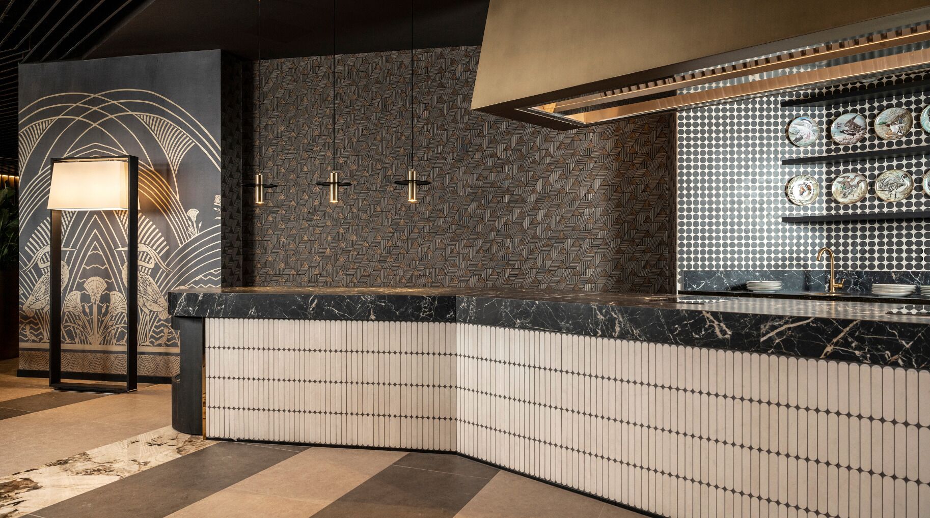 A modern kitchen with a curved countertop, a patterned backsplash, and a wall-mounted shelf with decorative plates.