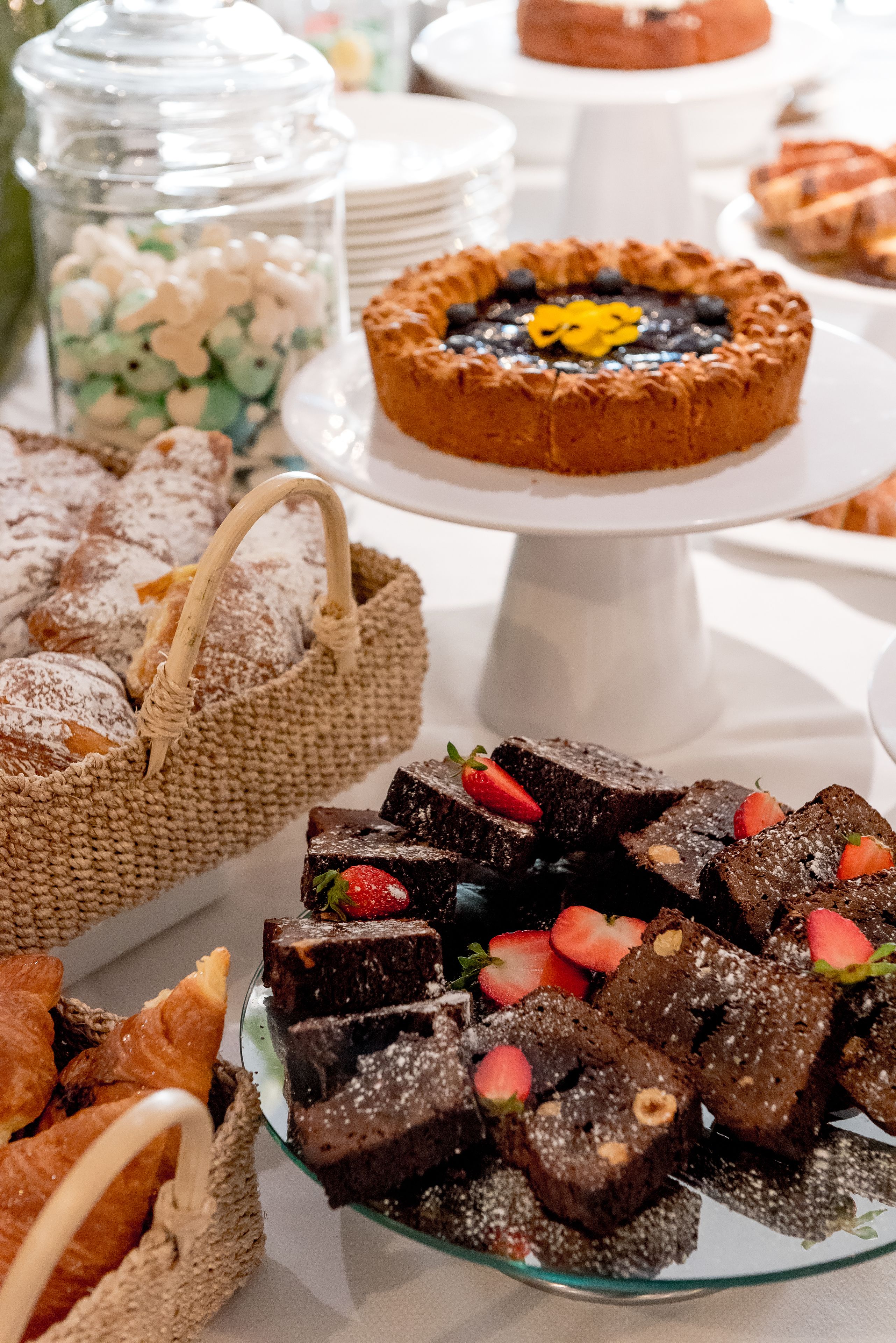 A dessert table with various baked goods and pastries.