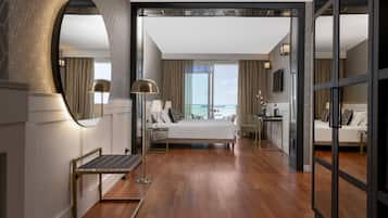 Une chambre d’hôtel moderne avec un grand lit, un bureau et une vue sur la mer.