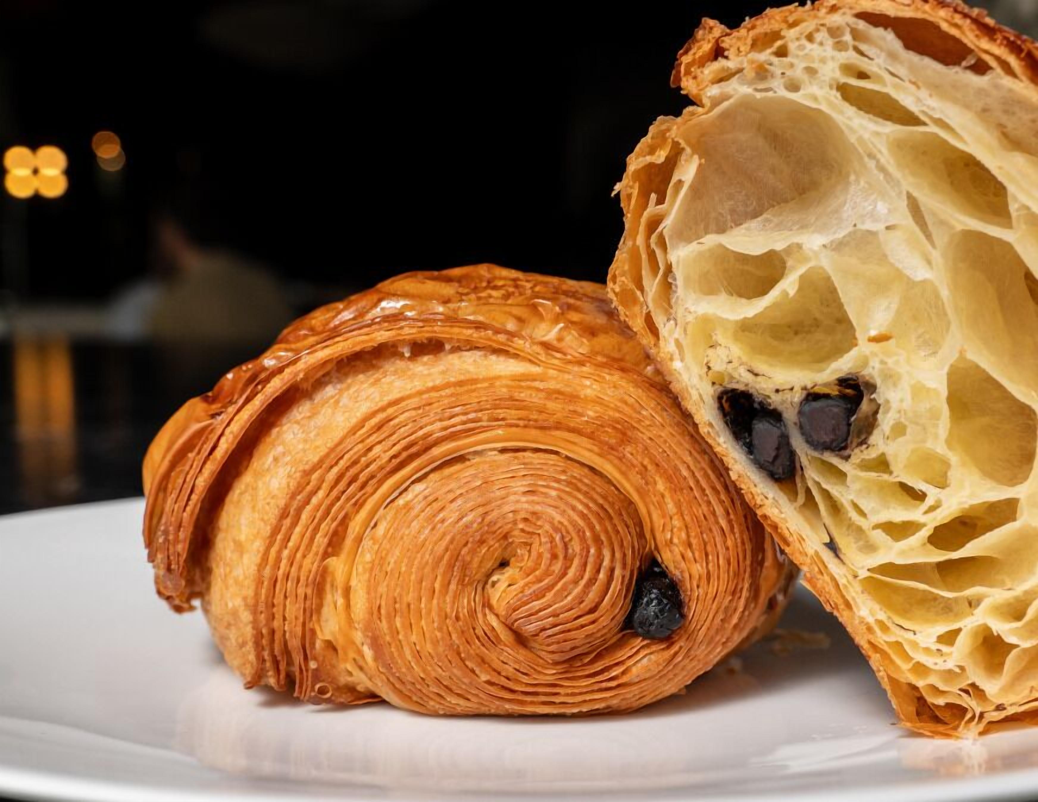 A croissant with chocolate filling on a plate.