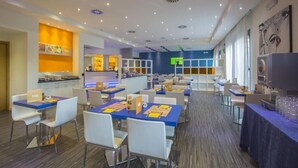 Un espace repas moderne avec des tables et des chaises, un coin cuisine et un bar.