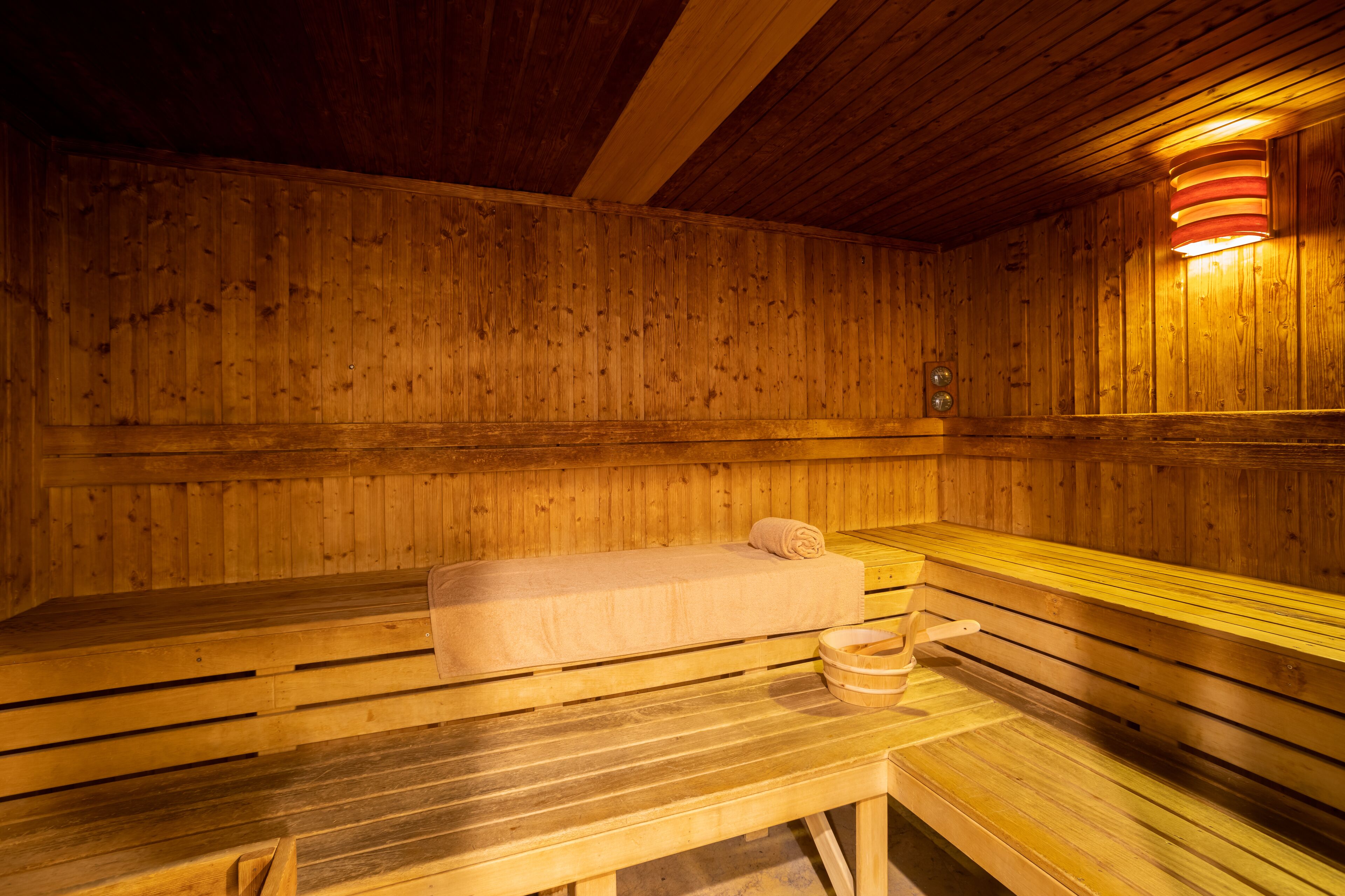 Una sauna de madera con bancos y un banco con toalla.