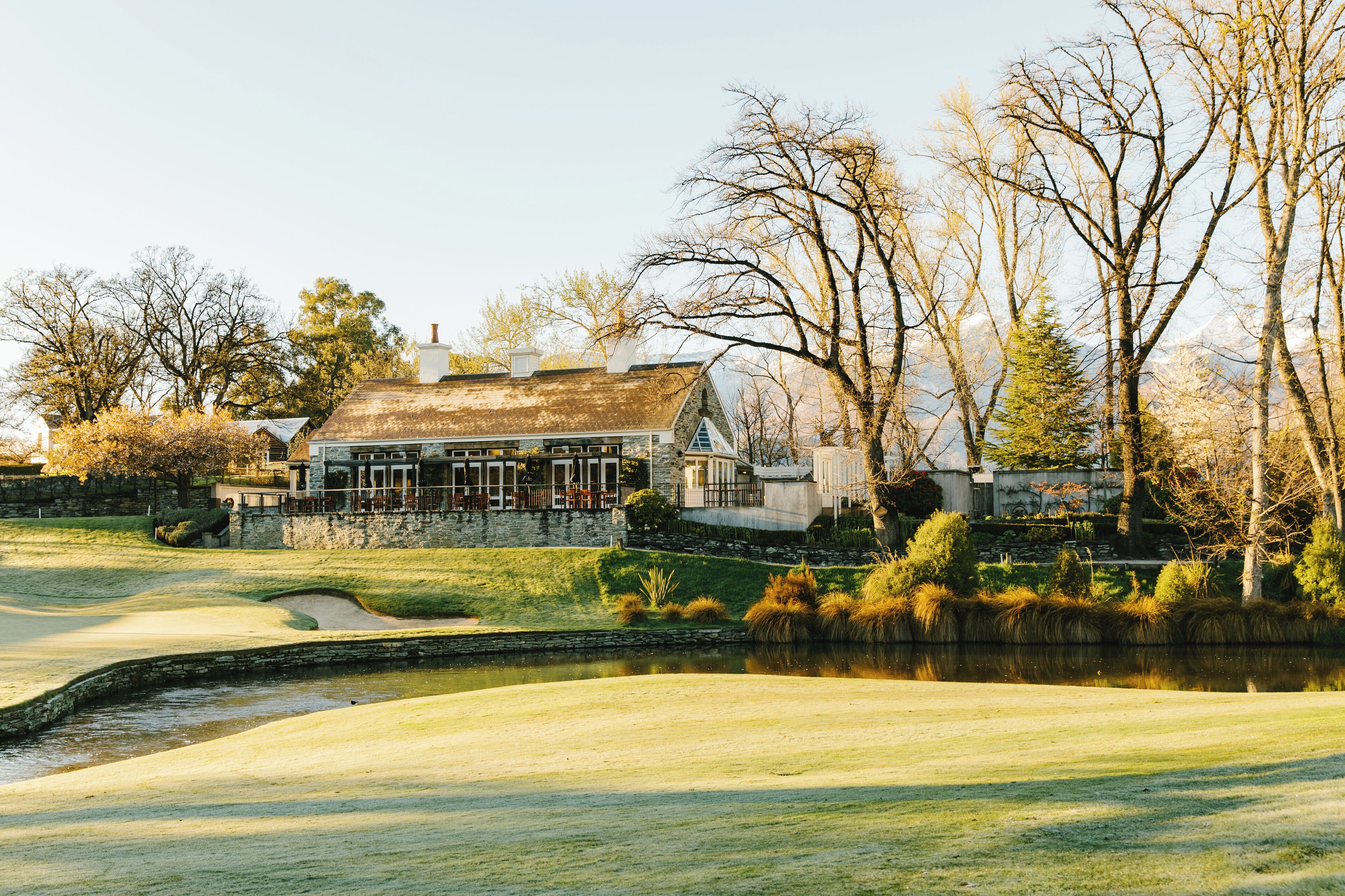 A golf course with a house in the background.