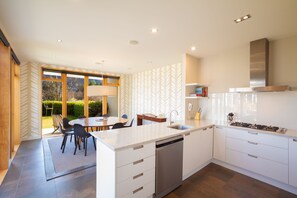 A modern kitchen with white cabinetry, a stainless steel dishwasher, and a gas stove.