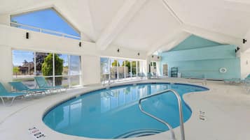 Una piscina techada, sillones reclinables de piscina