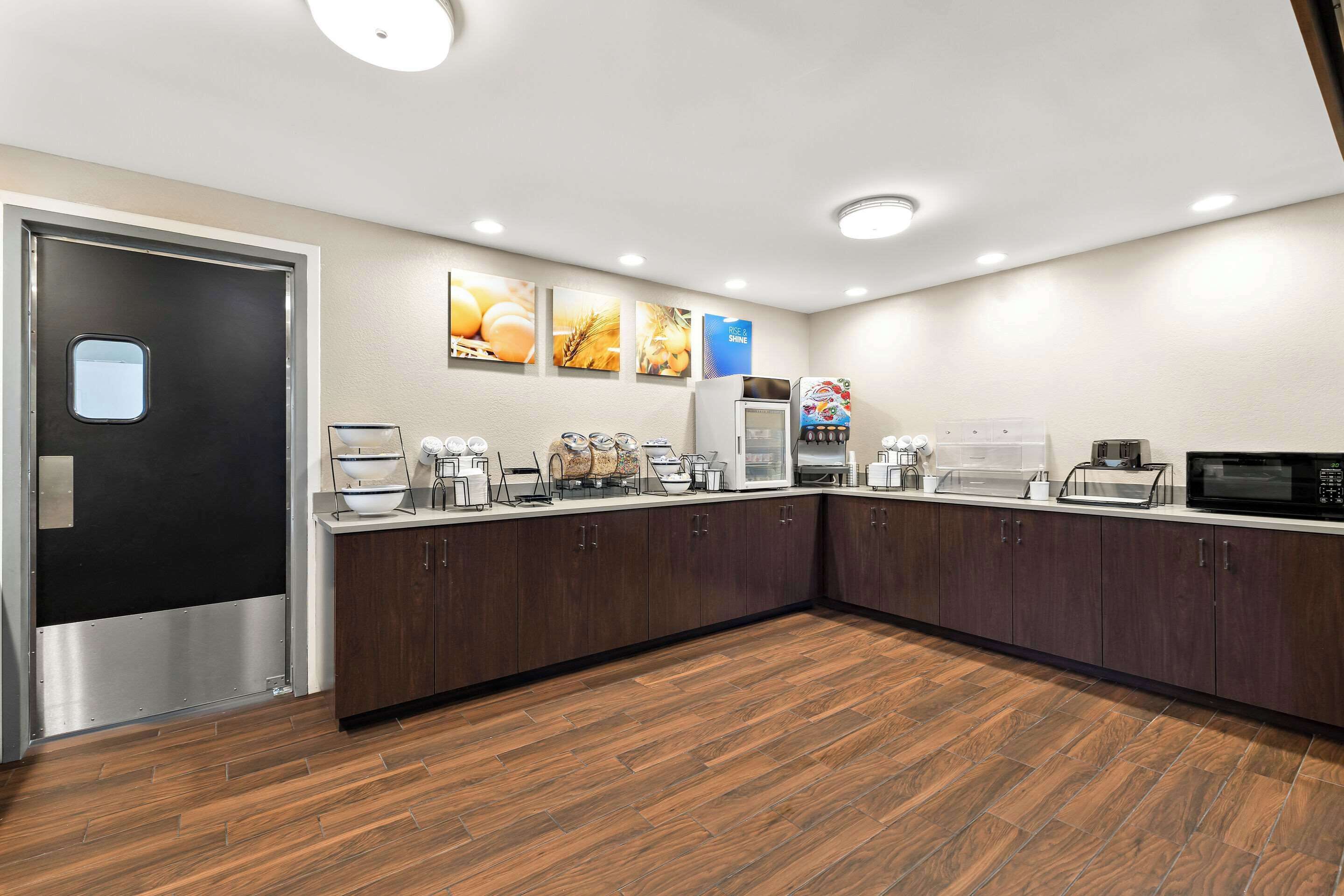Una cocina moderna con armarios de madera oscura, electrodomésticos de acero inoxidable y piso de madera.