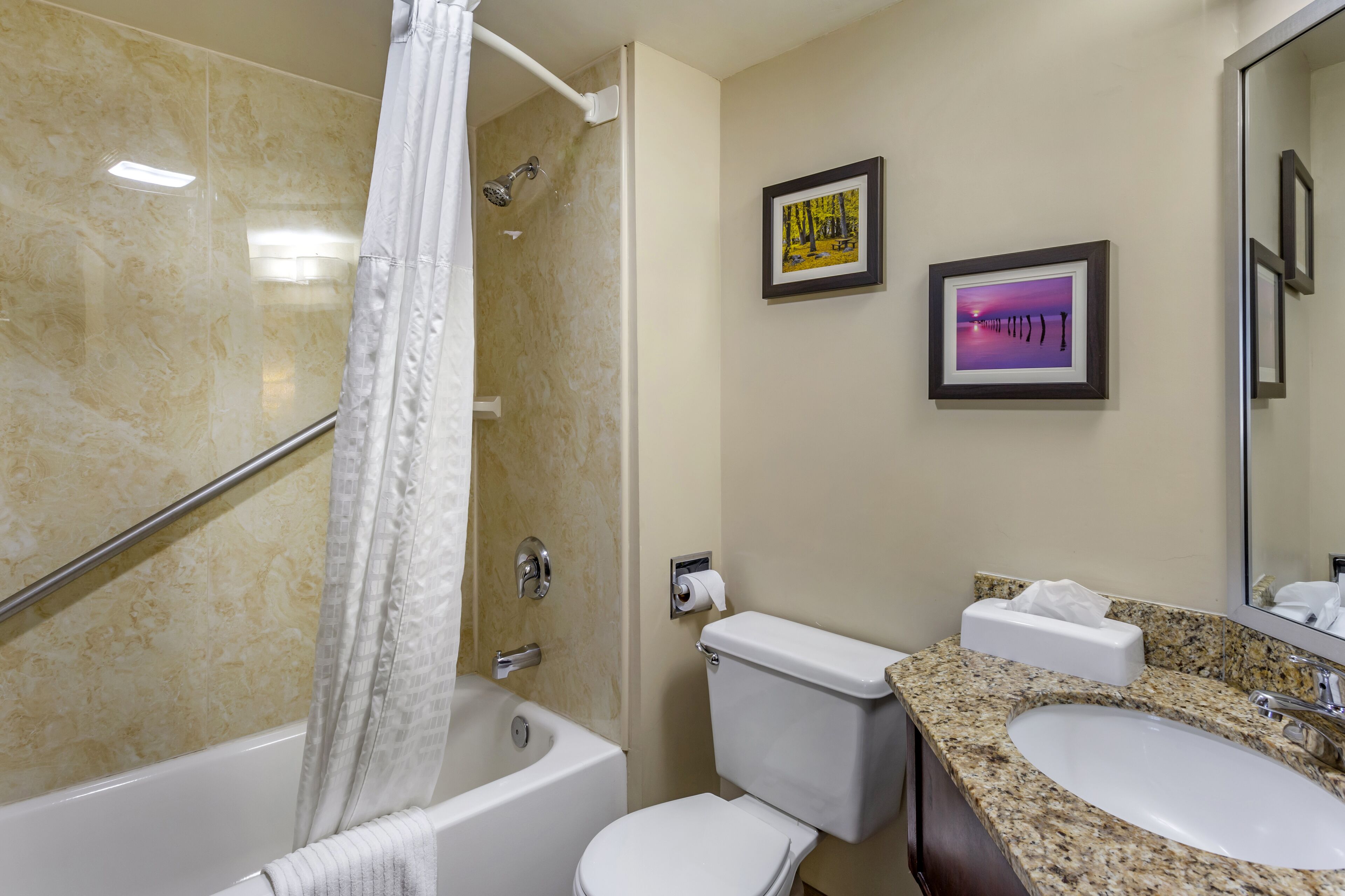 A bathroom with a bathtub, toilet, and sink.