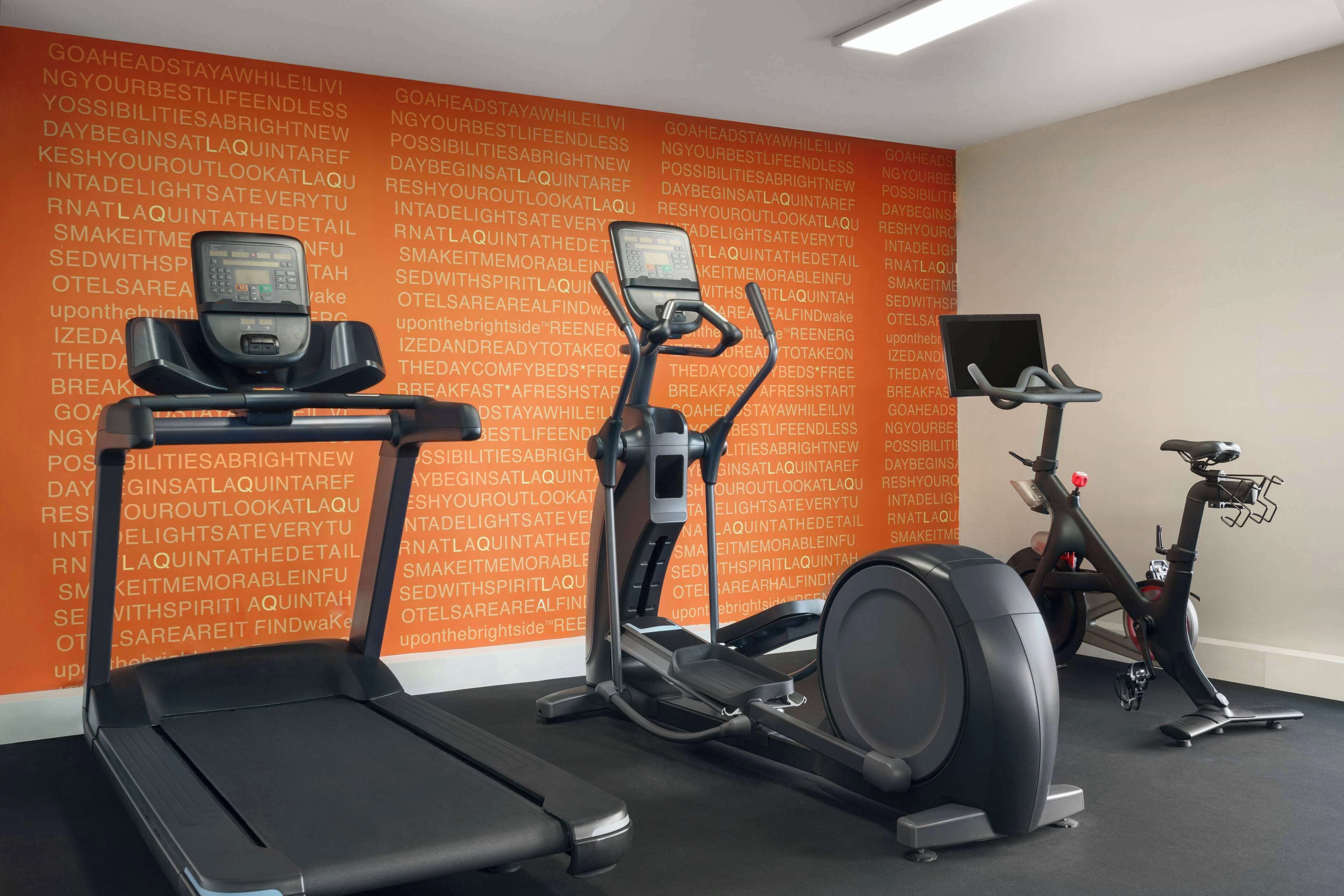 A gym with treadmills, elliptical machines, and a stationary bike.