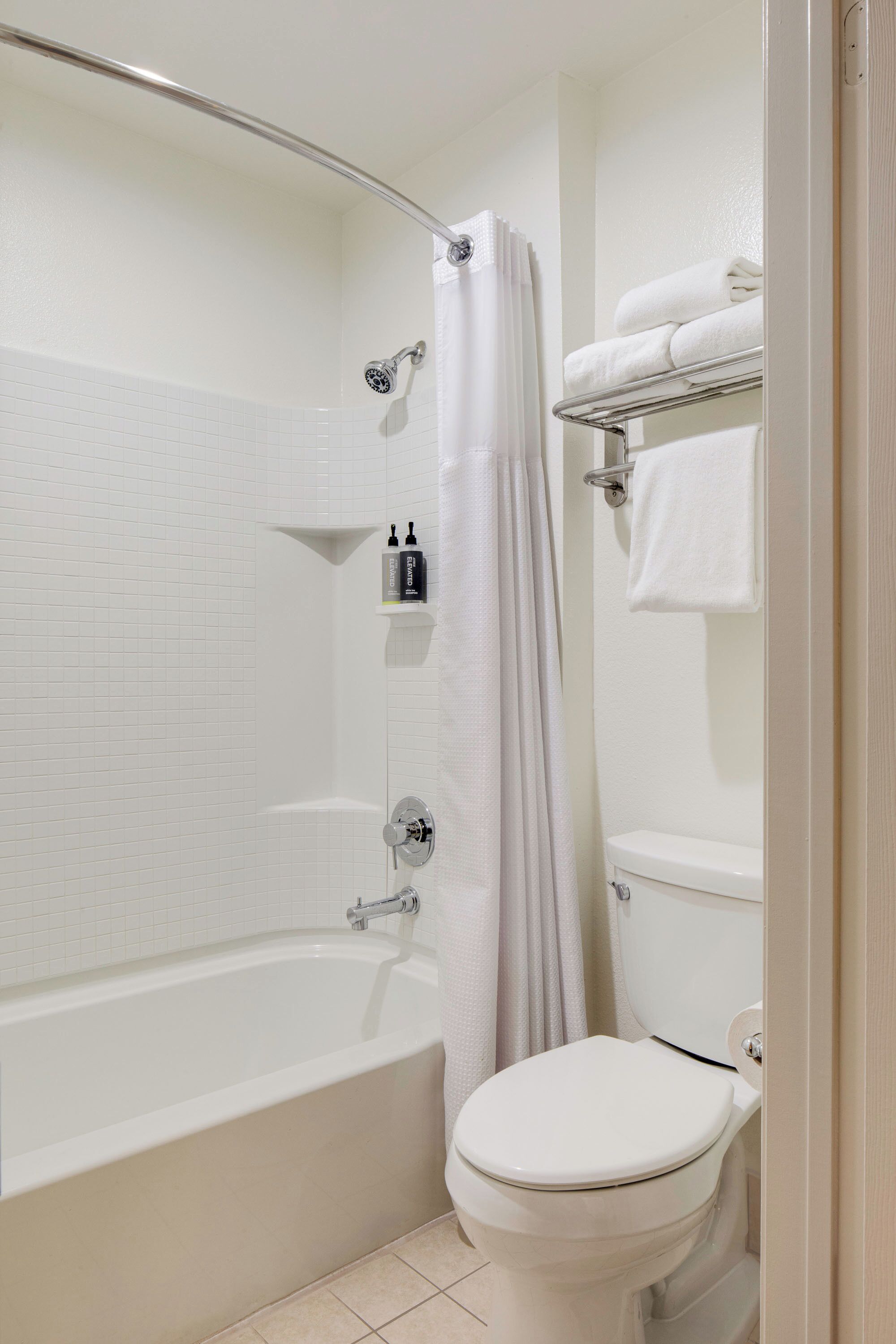A bathroom with a bathtub, toilet, and a shower area.