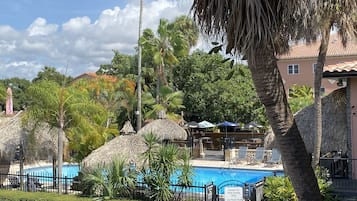 Una piscina al aire libre, sillones reclinables de piscina