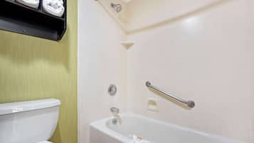 Une salle de bain avec une baignoire blanche, des toilettes et une étagère avec des serviettes.
