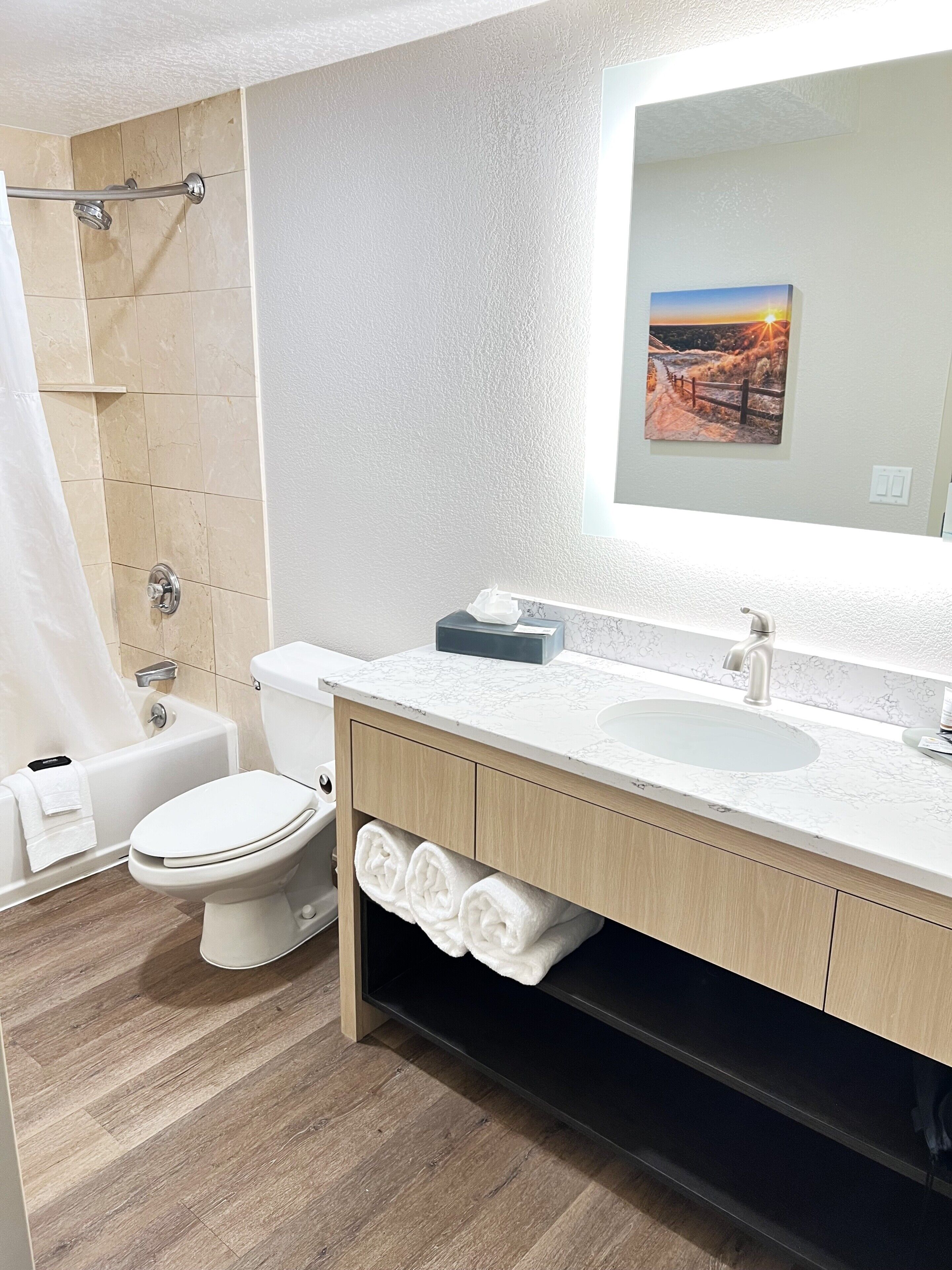 A modern bathroom with a toilet, sink, and shower area.