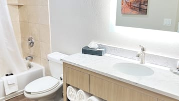 Un baño moderno con inodoro, lavamanos y zona de ducha.