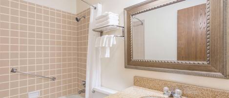 Une salle de bain avec une baignoire, un lavabo et un miroir.