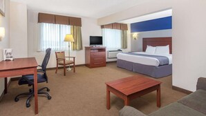 Ein Hotelzimmer mit Bett, Schreibtisch, Stuhl und Fernseher.