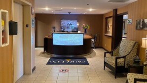A reception area with a large desk, a flat-screen TV, and a reception desk.