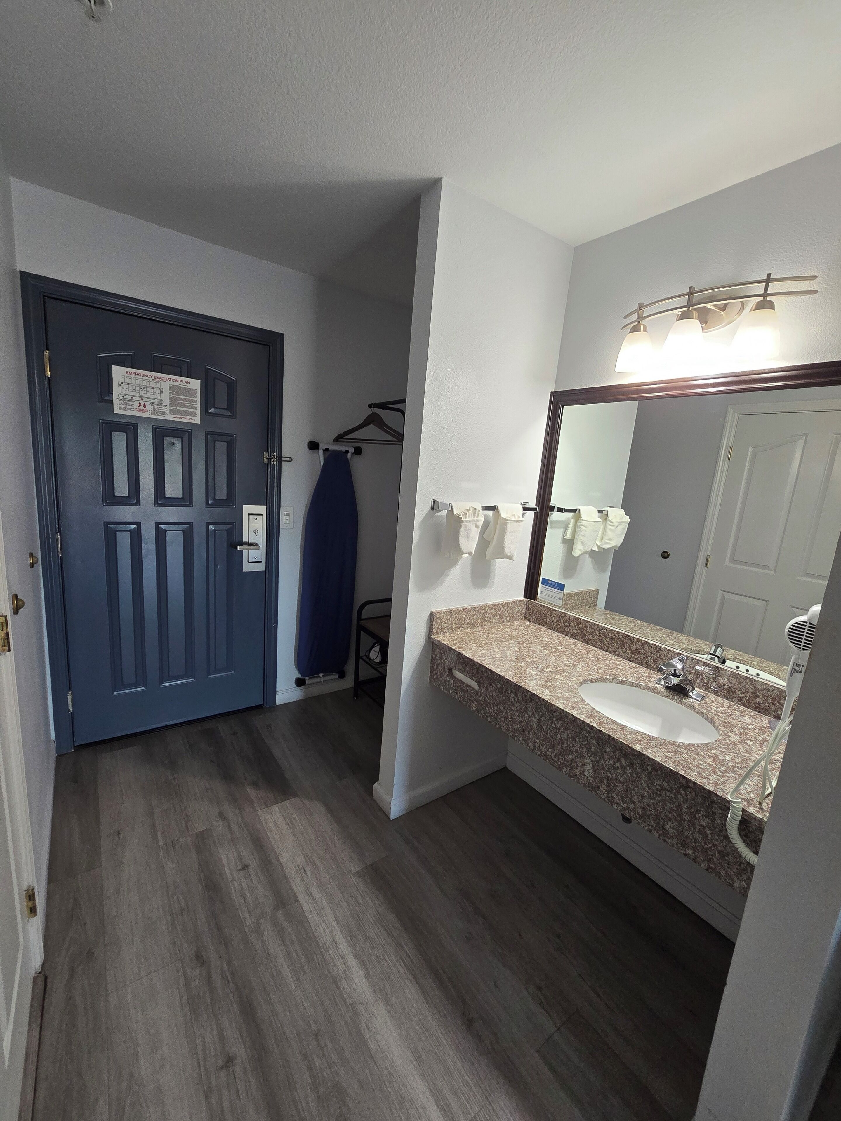 A bathroom with a sink, mirror, and towel rack.