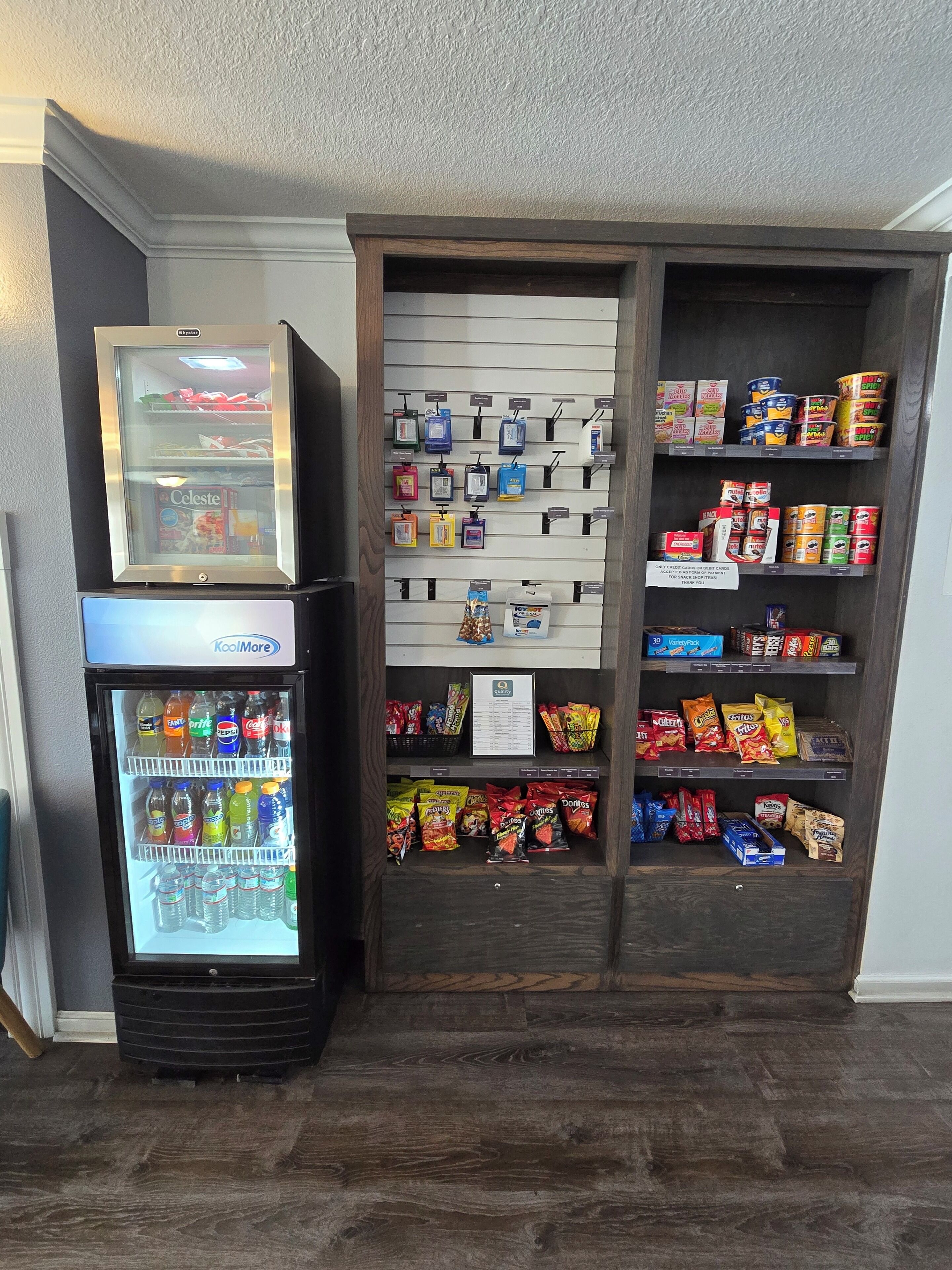 Un distributeur automatique rempli de boissons et d’en-cas, ainsi qu’un présentoir où sont exposés divers produits alimentaires et boissons.
