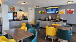 Un restaurant avec un comptoir, un espace pour s’asseoir et un téléviseur diffusant une publicité.
