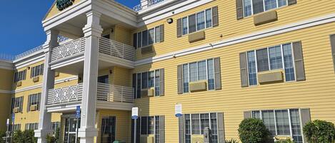 Un edificio giallo con ingresso bianco e un cartello con la scritta 'Quality Inn & Suites'.
