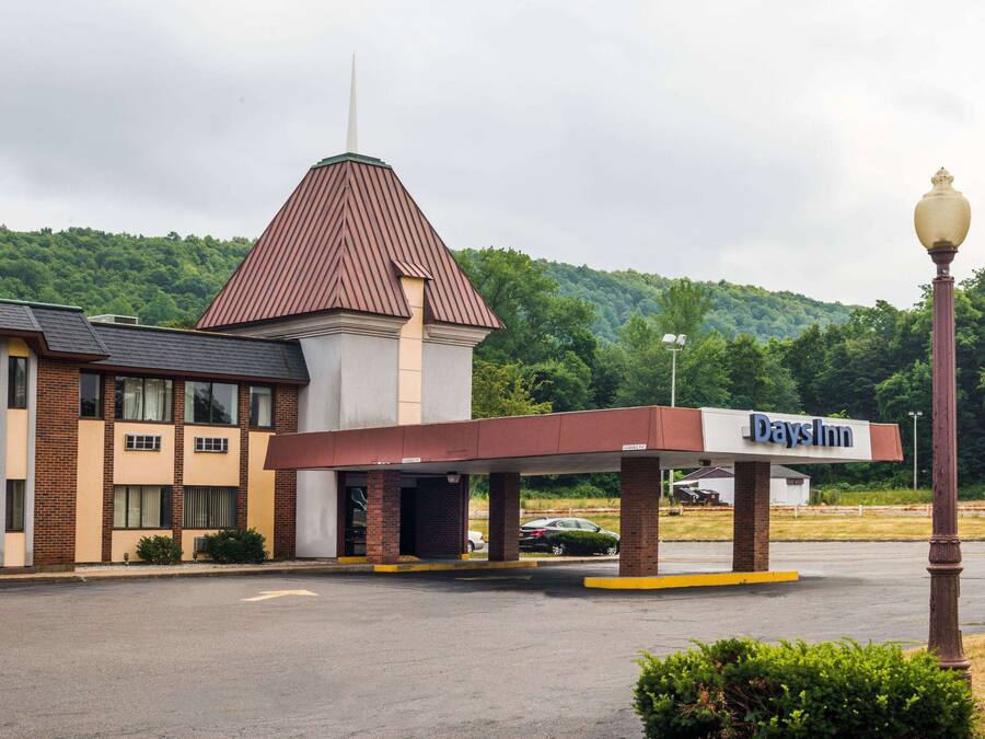 A Days Inn with a distinctive tower and a covered parking area.