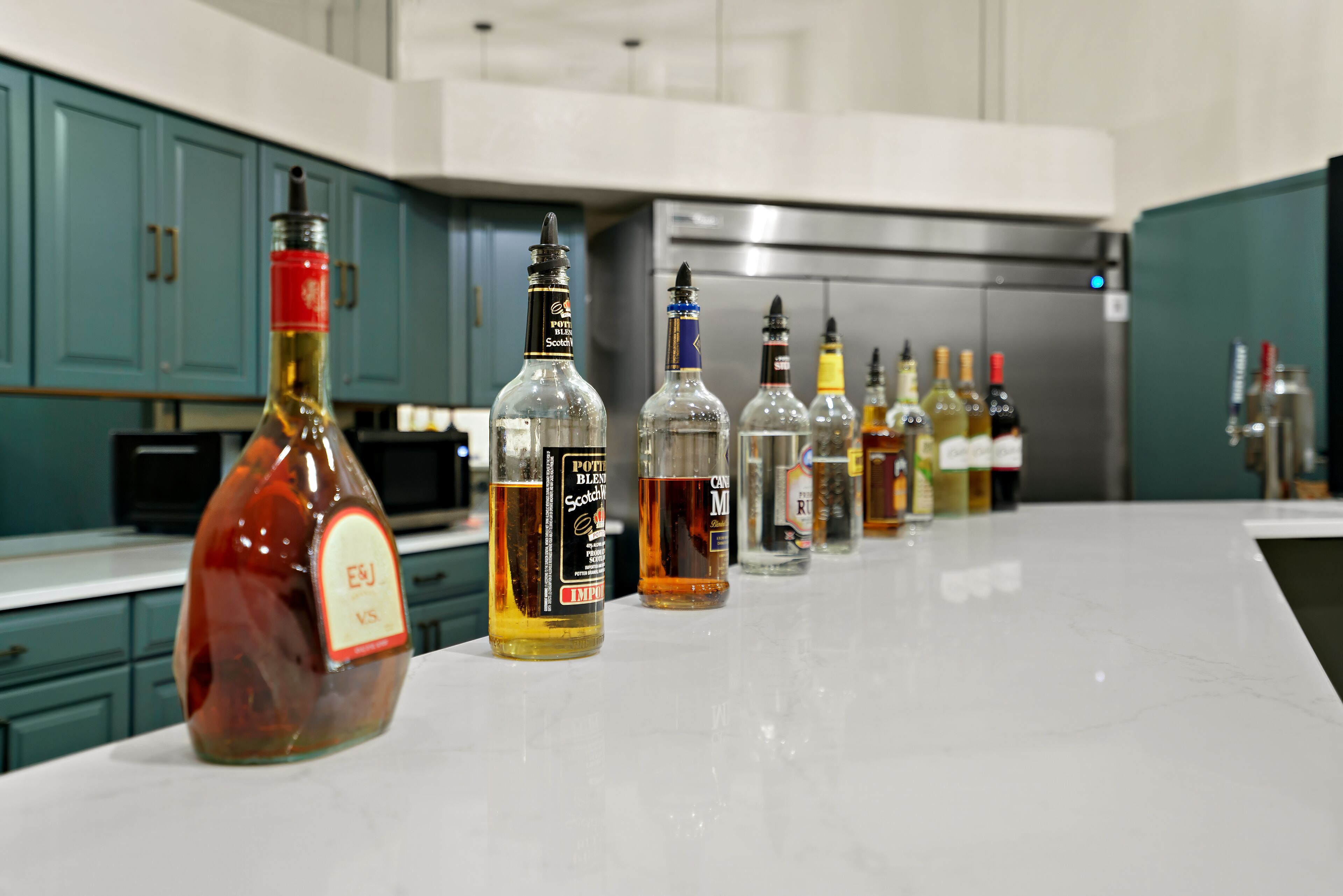 A kitchen counter with various bottles of alcohol.