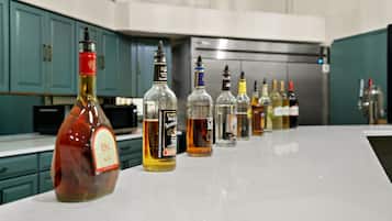 A kitchen counter with various bottles of alcohol.
