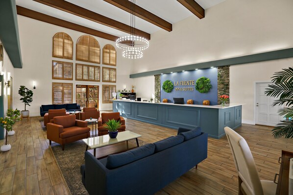 Relax in the spacious lobby with comfortable seating and potted plants.