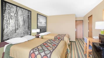 Habitación de hotel con dos camas, un escritorio, una silla, un televisor y una puerta.