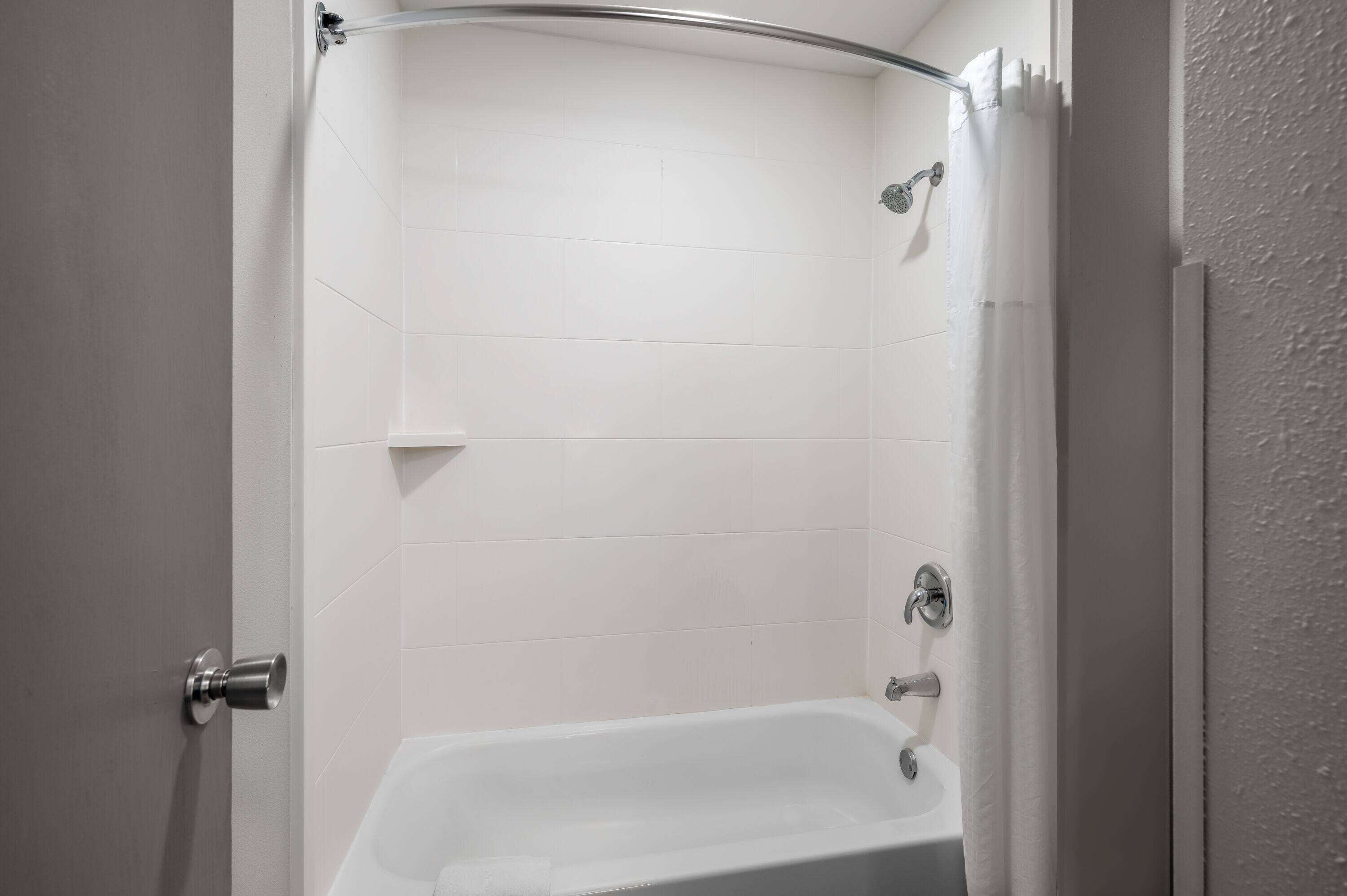 Une salle de bain avec une douche, une baignoire et des toilettes.