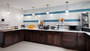 Una cocina moderna con armarios de madera oscura, encimera blanca y salpicadero con azulejos azules.