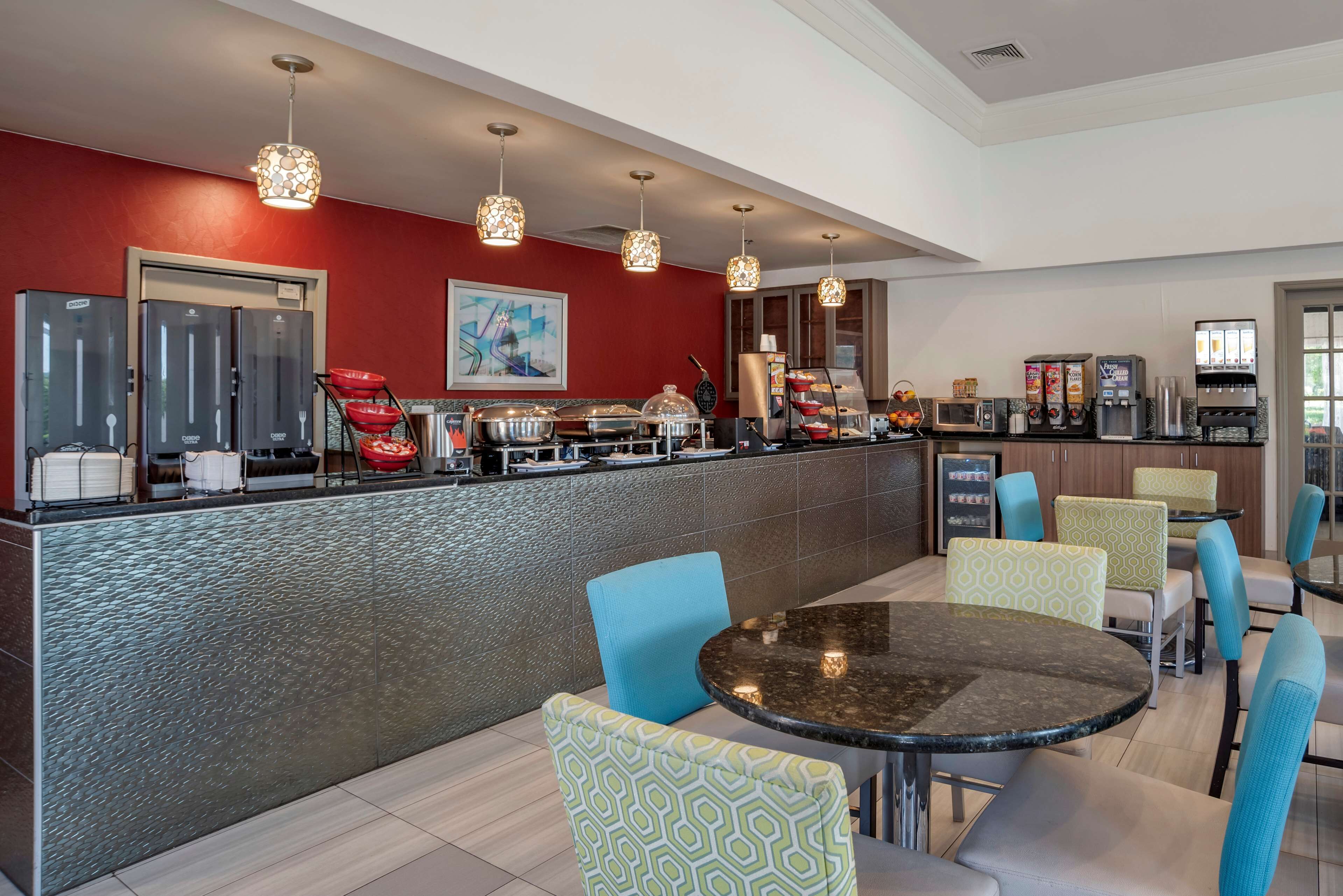 Eine moderne Hotelhalle mit Rezeption, Sitzgelegenheiten und einer Kaffeestation.