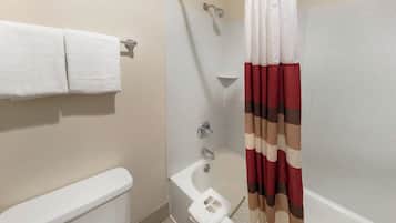 Un baño con inodoro, ducha con cortina y un perchero para toallas.