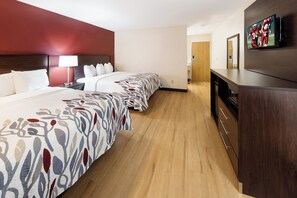 A hotel room with two beds, a TV, a desk, and a mirror. - Red Roof Inn Fort Wayne (Fort Wayne)