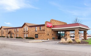 A Red Roof Inn with a brick facade, a covered entrance, and a parking lot.